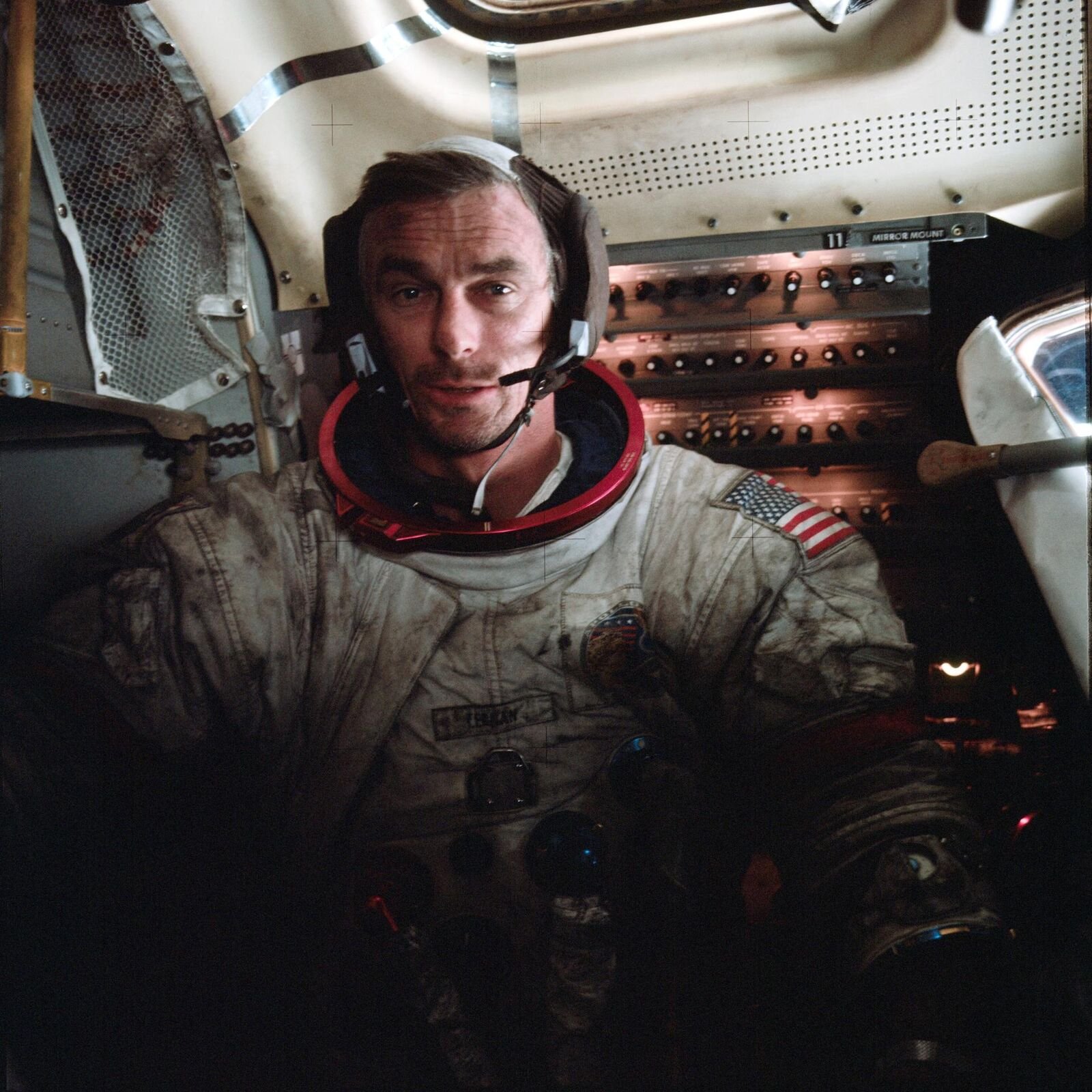 Astronauta Eugene Cernan dentro do módulo lunar, com o traje coberto de poeira lunar